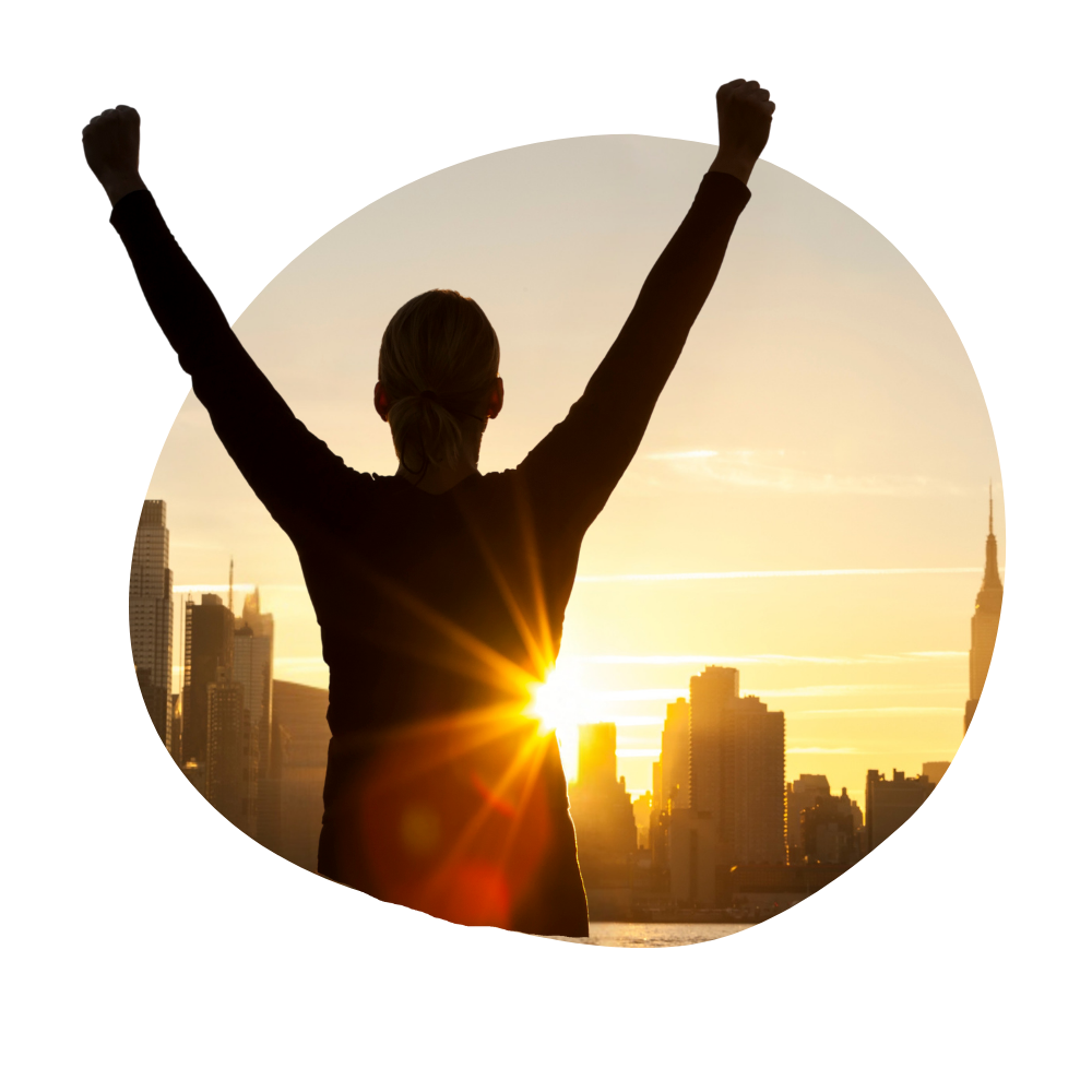 Someone raising their hands in success in front of a sunset