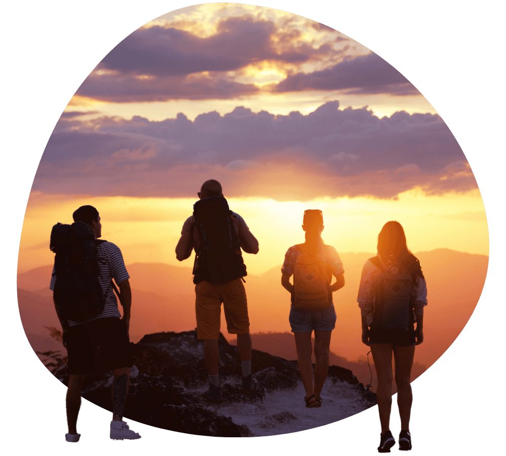 A group gazing at the sunset at a mountain peak